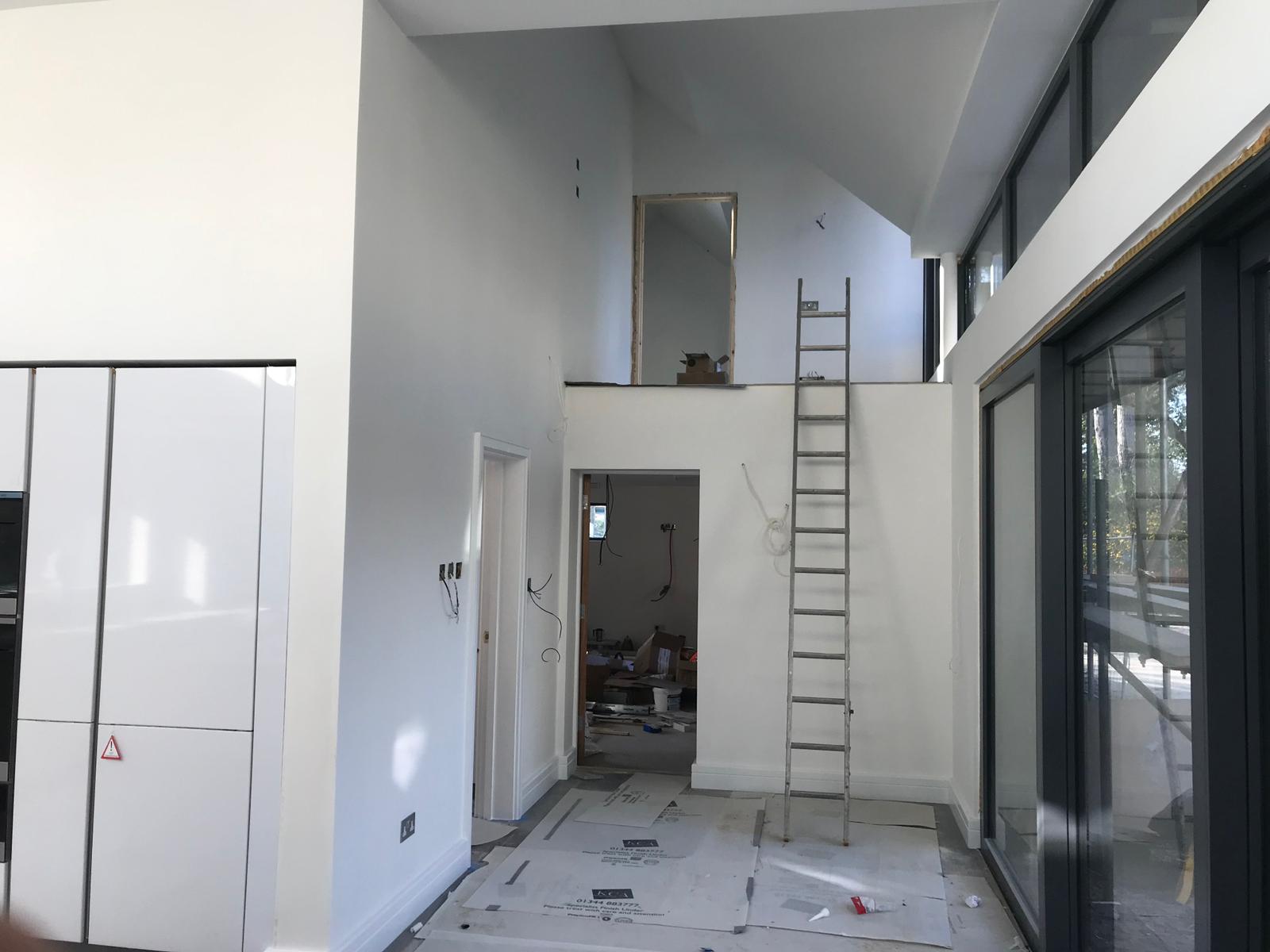Double-height open plan space with mezzanine and full-height windows