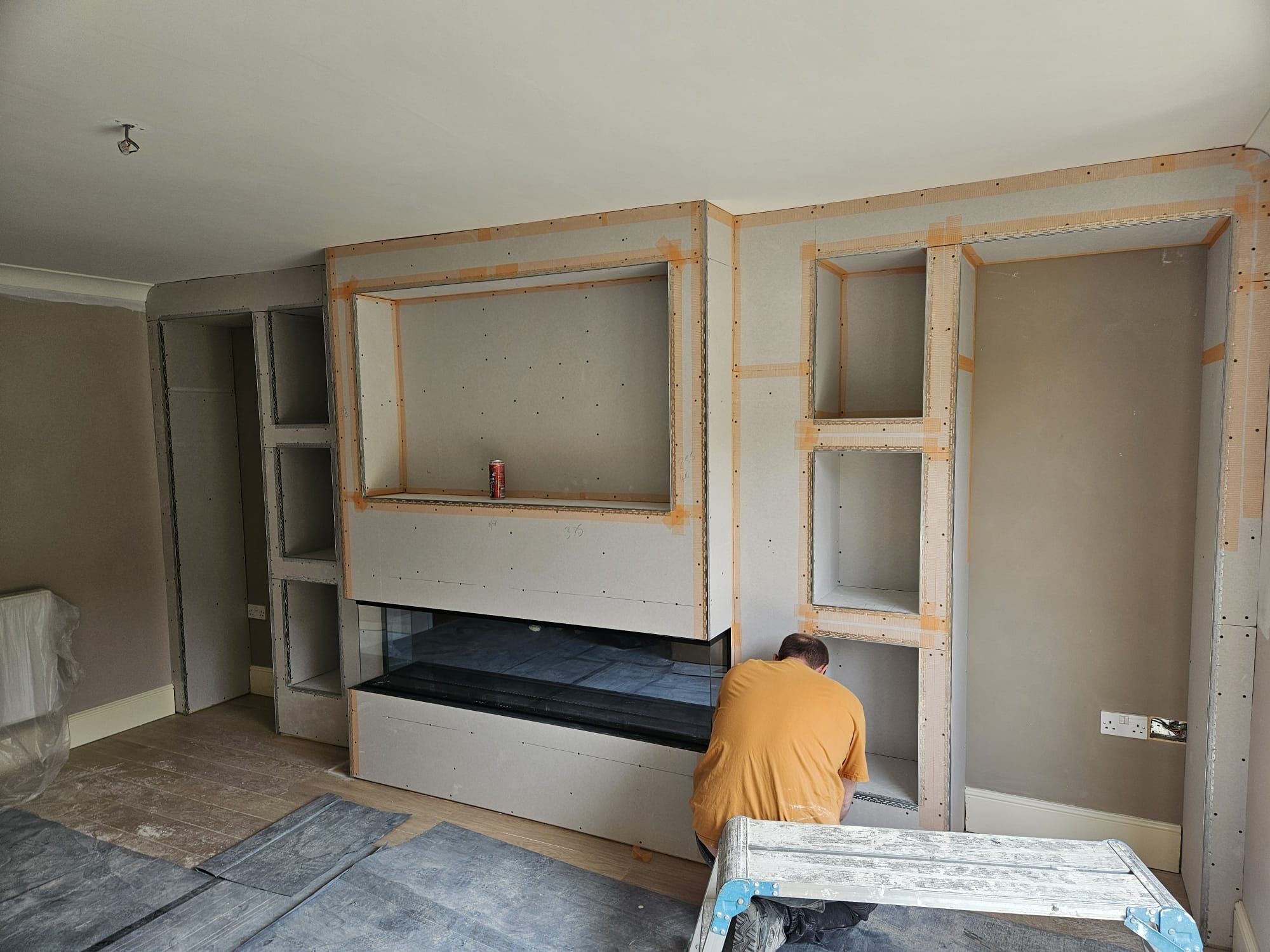 Plasterboarded media wall with scrim-taped joints, ready to skim