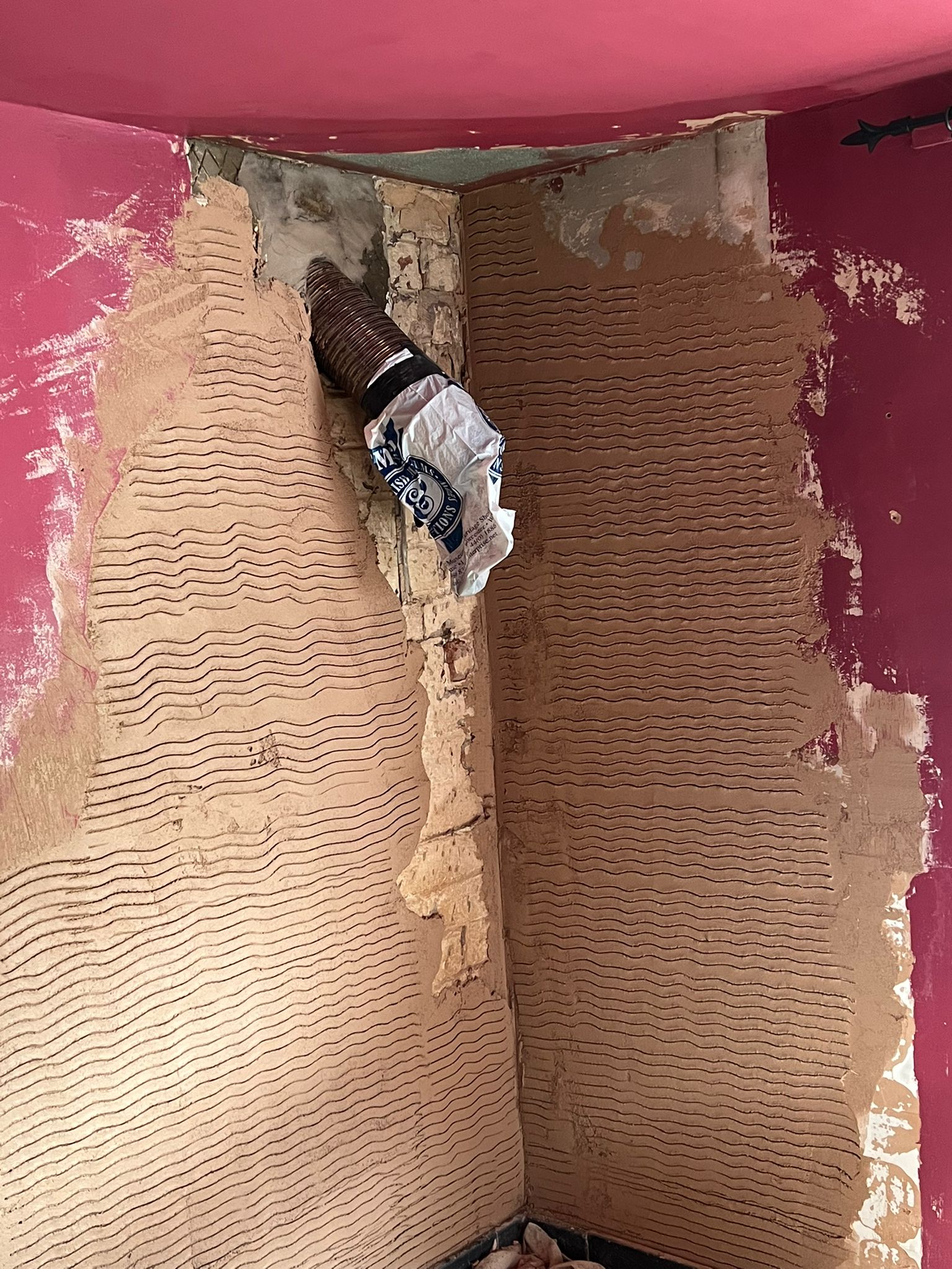 Scratch coat plastering in progress on alcove walls