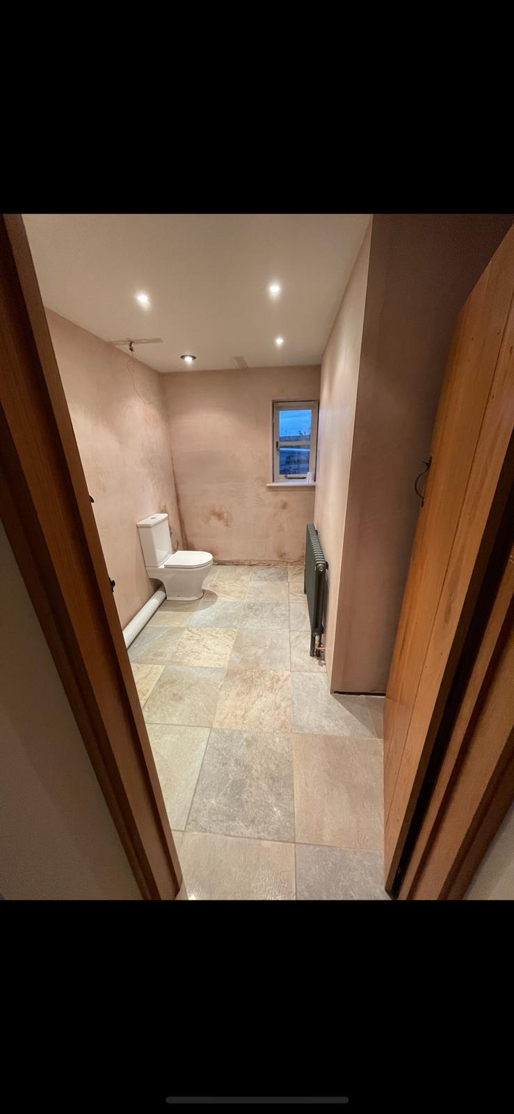 Bathroom freshly plastered with downlights and stone floor