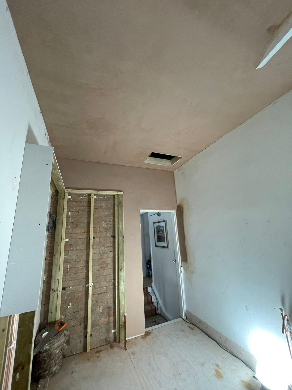 Room with freshly skimmed ceiling and stud wall being built