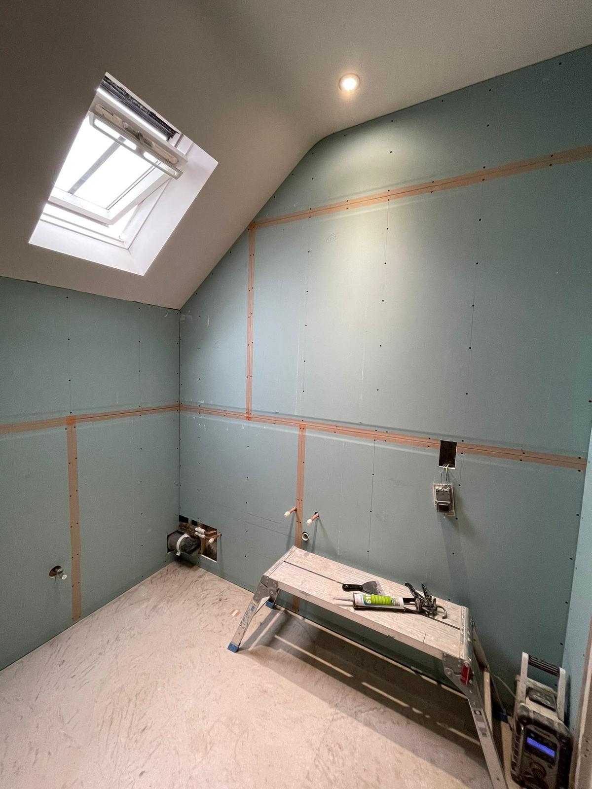 Loft bathroom boarding with moisture-resistant green board and Velux