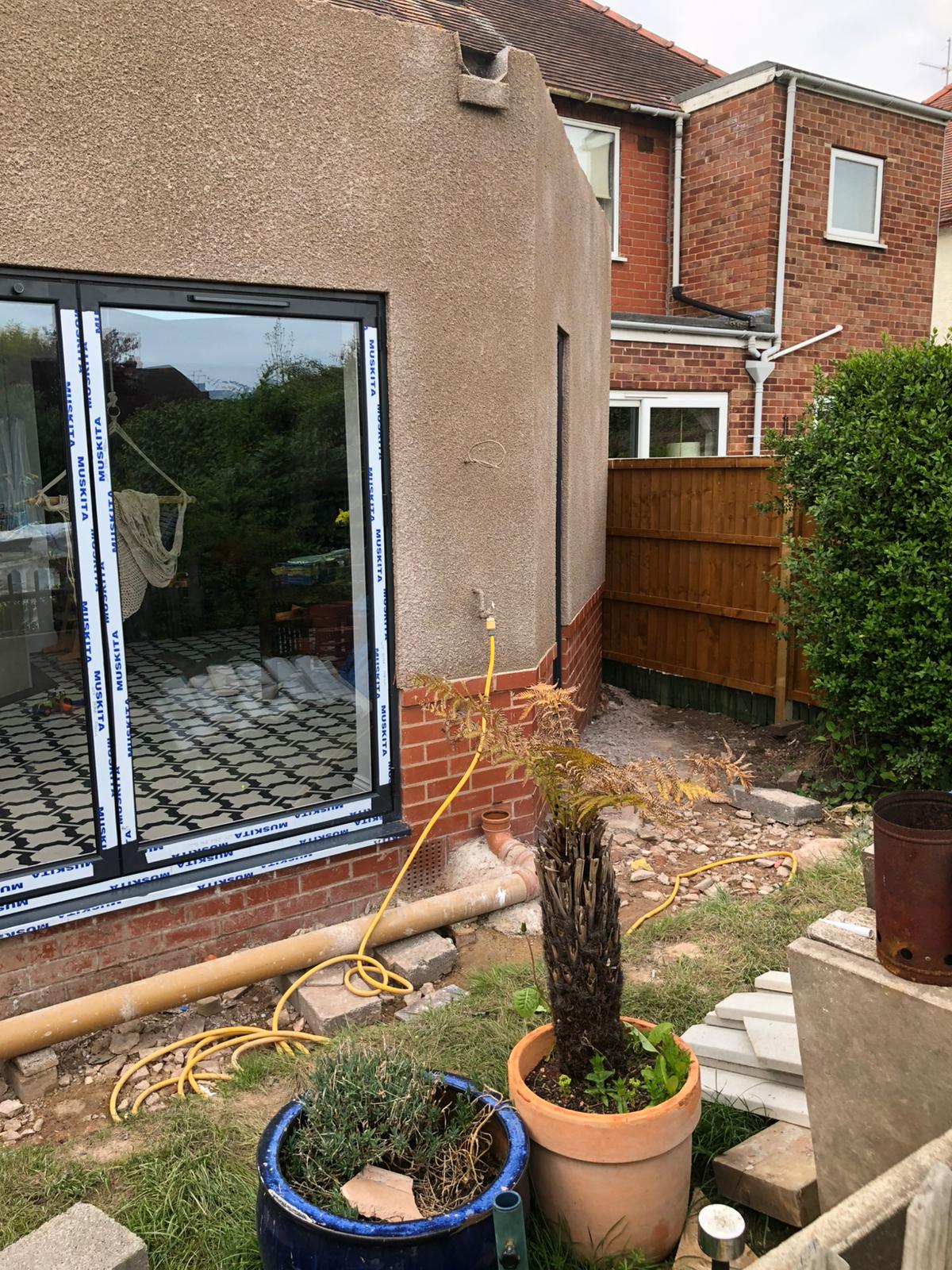 Rendered extension exterior with sliding doors and patio